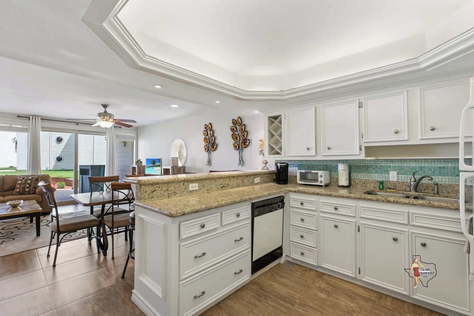 A spacious kitchen with a granite countertop and stainless steel appliances