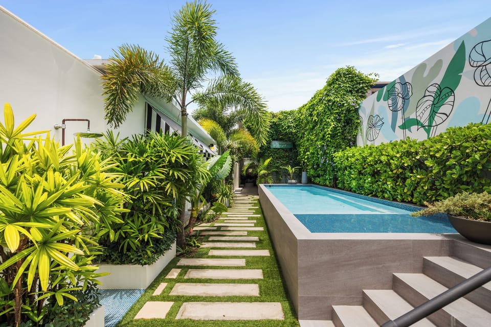 Step into tranquility at our secluded pool area, featuring vibrant tropical plants.