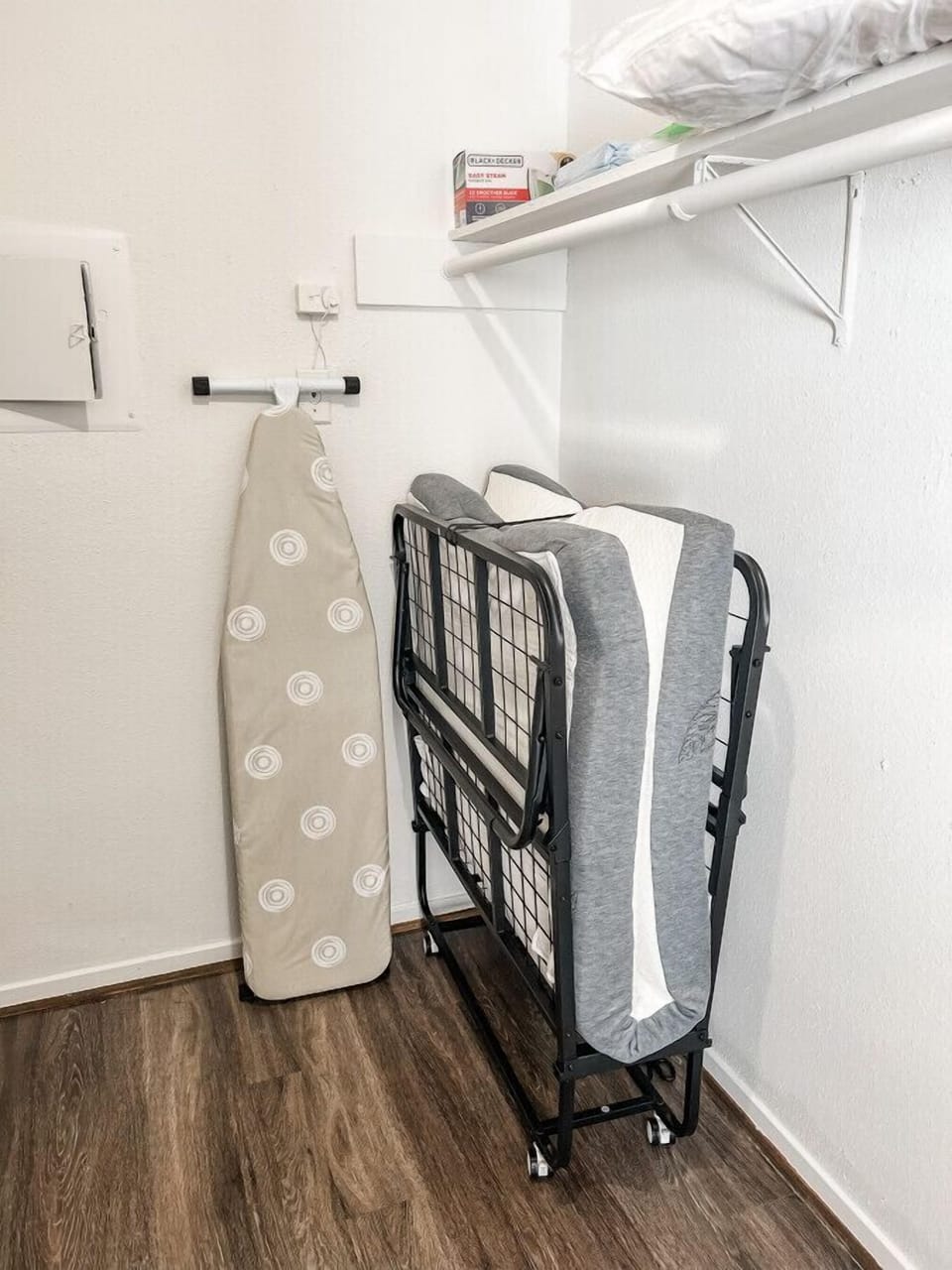An iron and ironing stand are conveniently located in the closet, along with an extra bed for additional guests.
