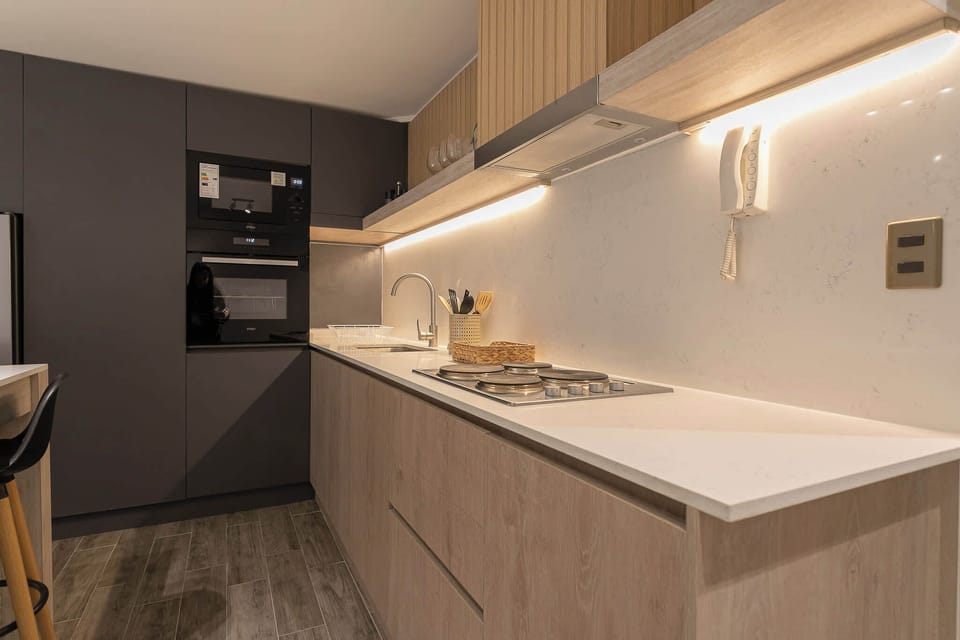Modern kitchen with sleek appliances and under-cabinet lighting, perfect for culinary adventures.