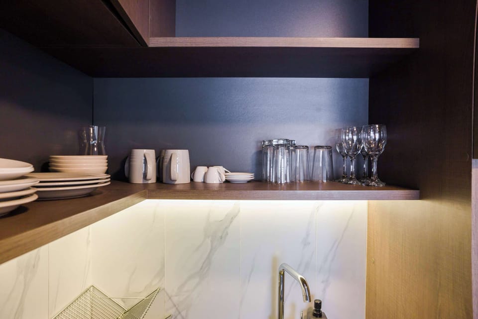 Sleek kitchen with stylish open shelving and modern amenities for a comfortable stay.