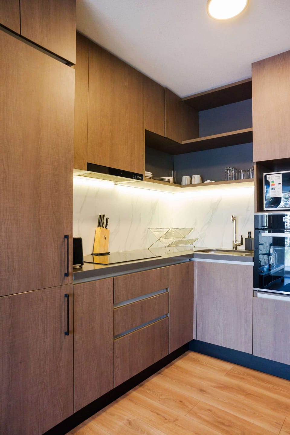 Sleek and modern kitchen with top-notch appliances and stylish wooden cabinetry, perfect for culinary adventures.