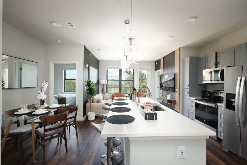 Gather around the table in our chic dining room, featuring a large mirror and a touch of nature with a white orchid.