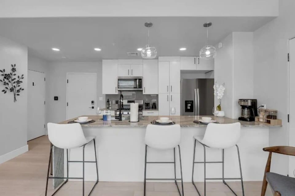Modern kitchen with all essentials and a bar counter for seating.