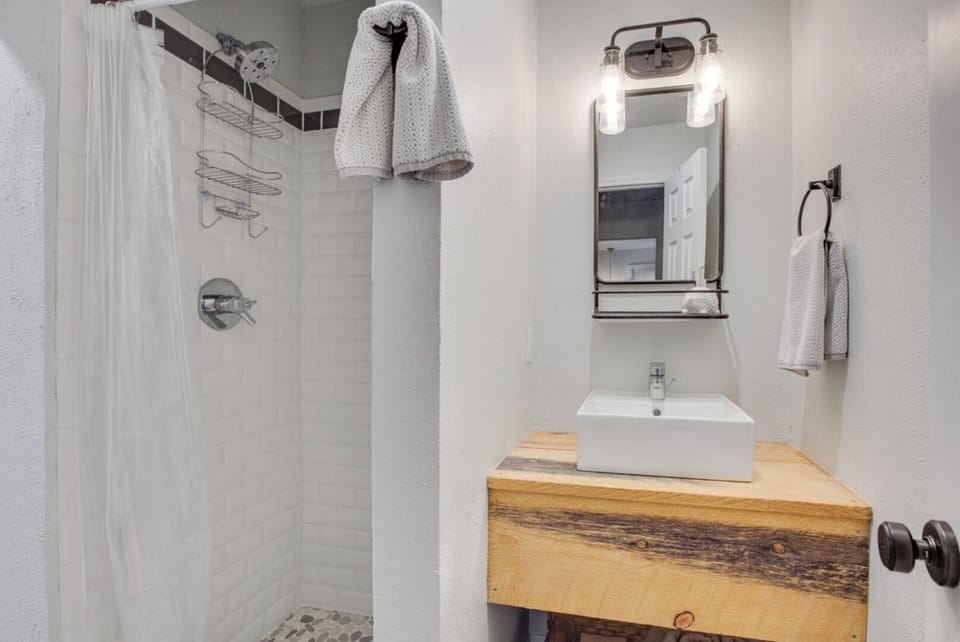 Refresh in your stylish, modern bathroom with a spacious walk-in shower, rustic wood vanity, and vessel sink—everything you need to unwind after a day of adventure.