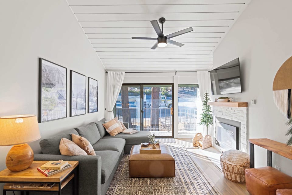 Living room with TV, gas fireplace, balcony access, and sofa sleeper