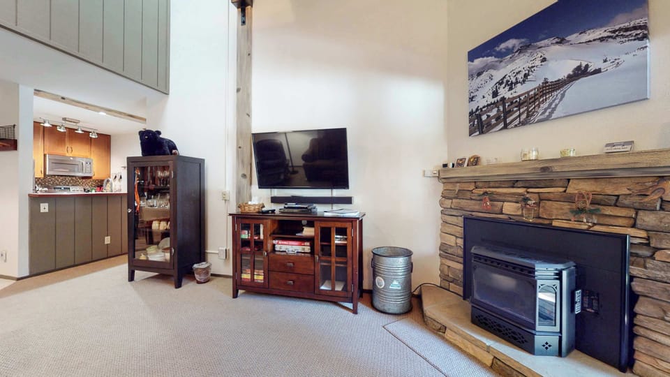 Cozy and spacious living area with TV and fireplace