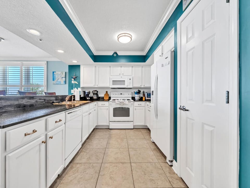 Cook your favorite meals in this bright, fully-equipped kitchen with granite counters and modern appliances.