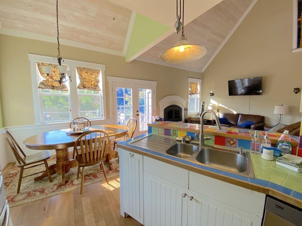 View from kitchen of breakfast nook, the bar, and the great room. Open, spacious and bright.  Prepare gourmet meals while still visiting with guests. Doors lead to outdoor deck with seating and bbq.