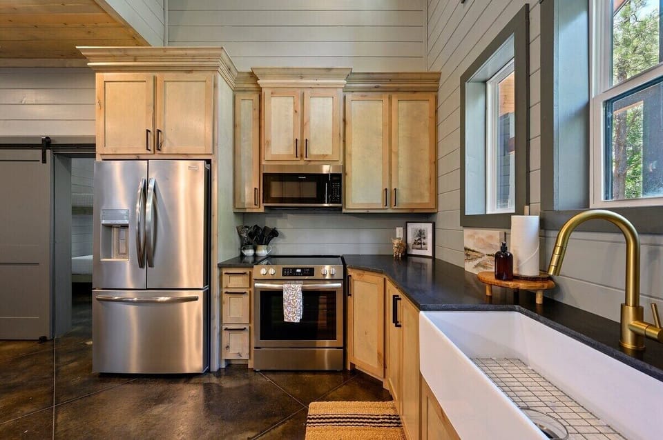 Spacious gourmet kitchen with stainless steel appliances, farmhouse sink, and rustic cabinetry.