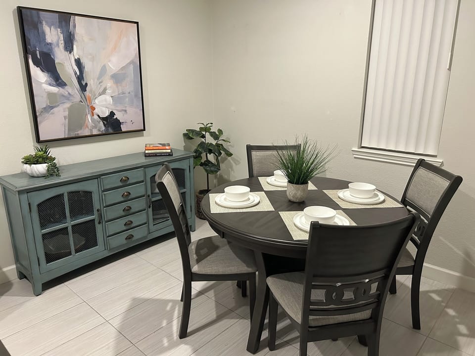Dining has room for 4. Buffet with serving dishes, coasters, wine glasses.
