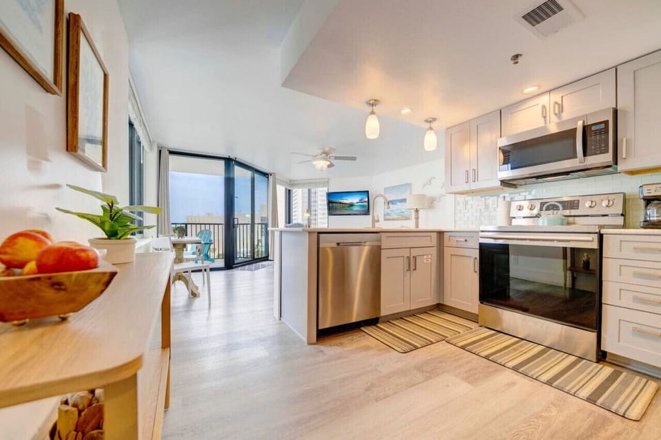 modern beach condo, featuring a completely remodeled kitchen equipped with top-of-the-line appliances and sleek finishes.