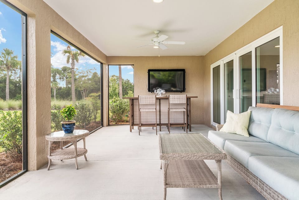Screened-in Lanai Overlooking the Sprawling Backyard with Flatscreen TV, Bar and Cozy Lounge Seating