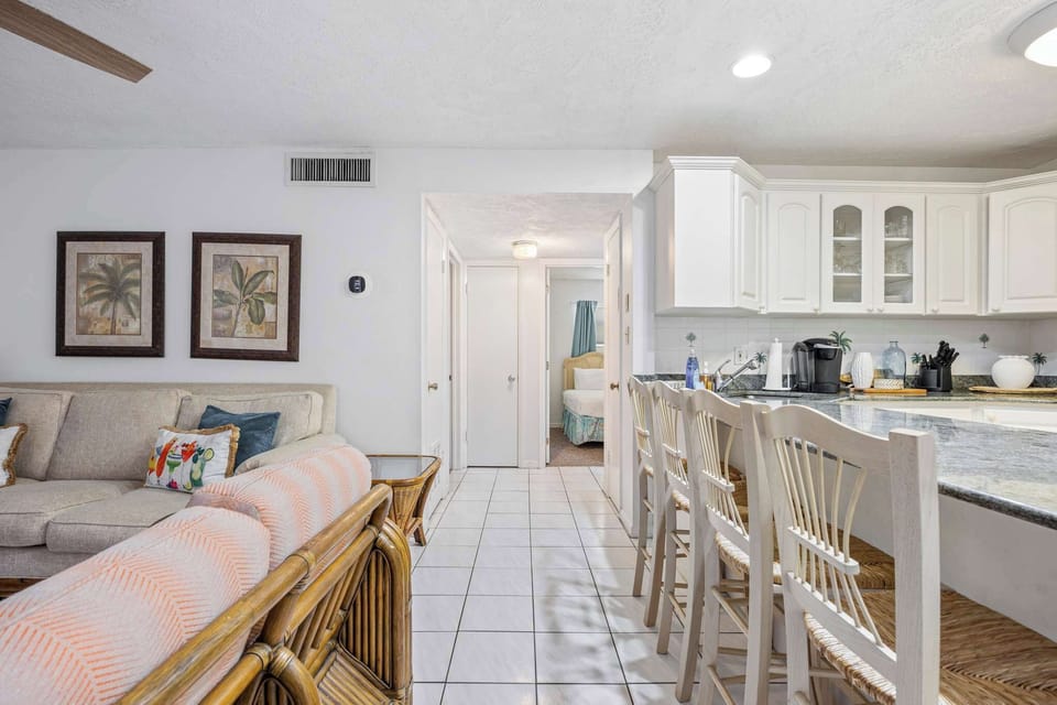 Open kitchen with white cabinetry and a breakfast bar overlooking the living area.
