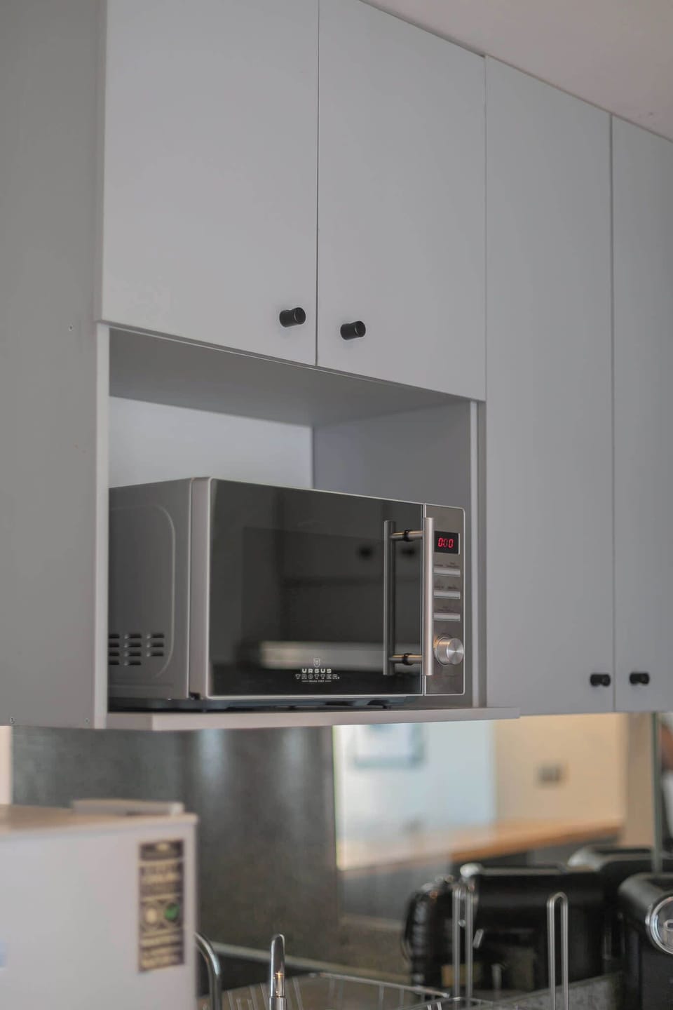 Modern kitchen with sleek cabinetry and convenient microwave for easy meal prep.