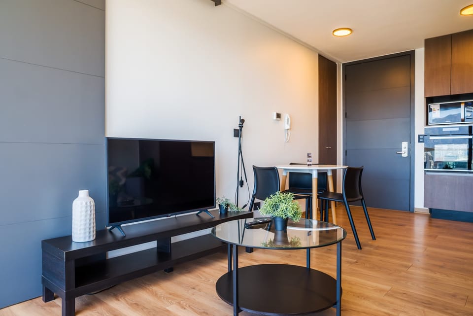 Modern living space with sleek furnishings and a cozy dining area, perfect for relaxing after exploring the city.