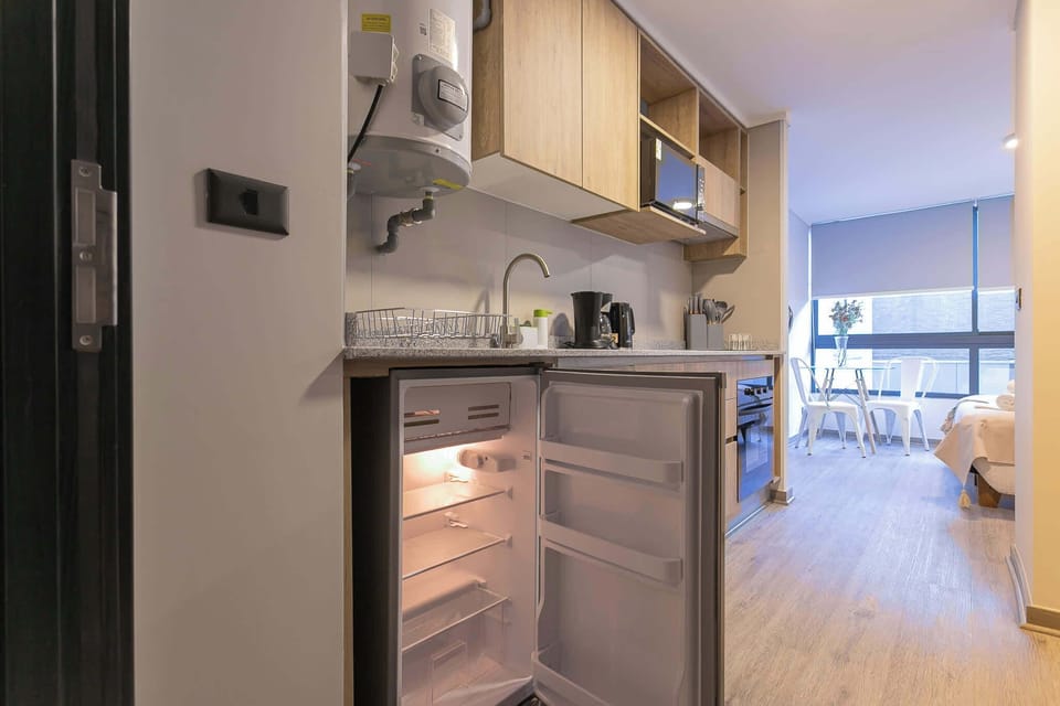 Cozy studio kitchen with modern amenities and a bright dining space, perfect for a comfortable stay.