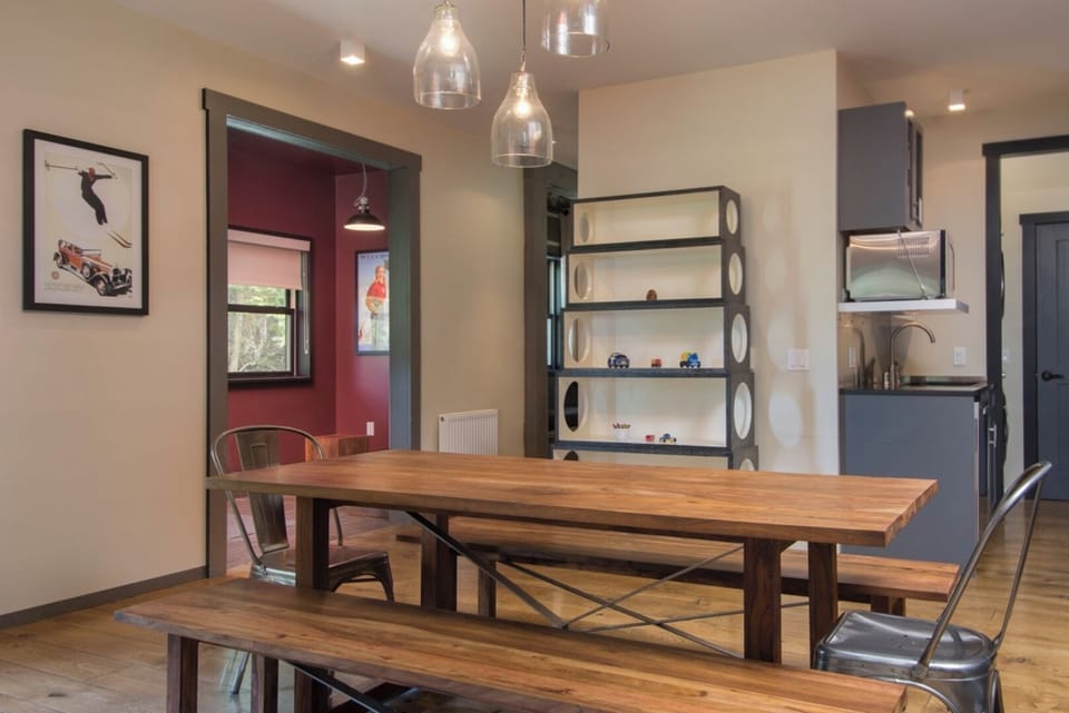 Gather around this inviting dining table where shared meals become cherished memories. The warm wood tones, stylish pendant lights, and open layout create a welcoming space for your group to connect and relax together.