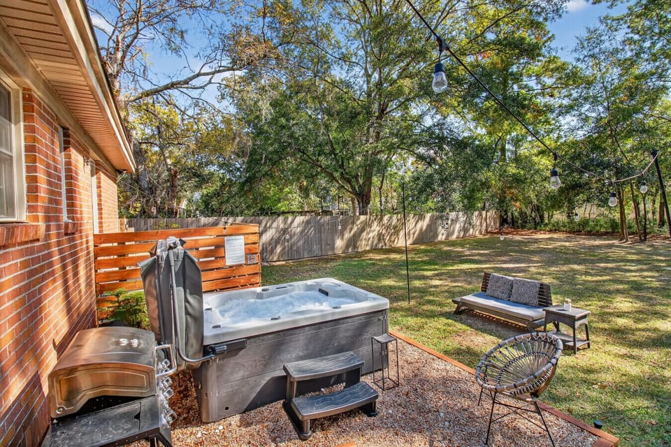 Slip into the private hot tub and soak beneath the trees — your peaceful backyard escape awaits.