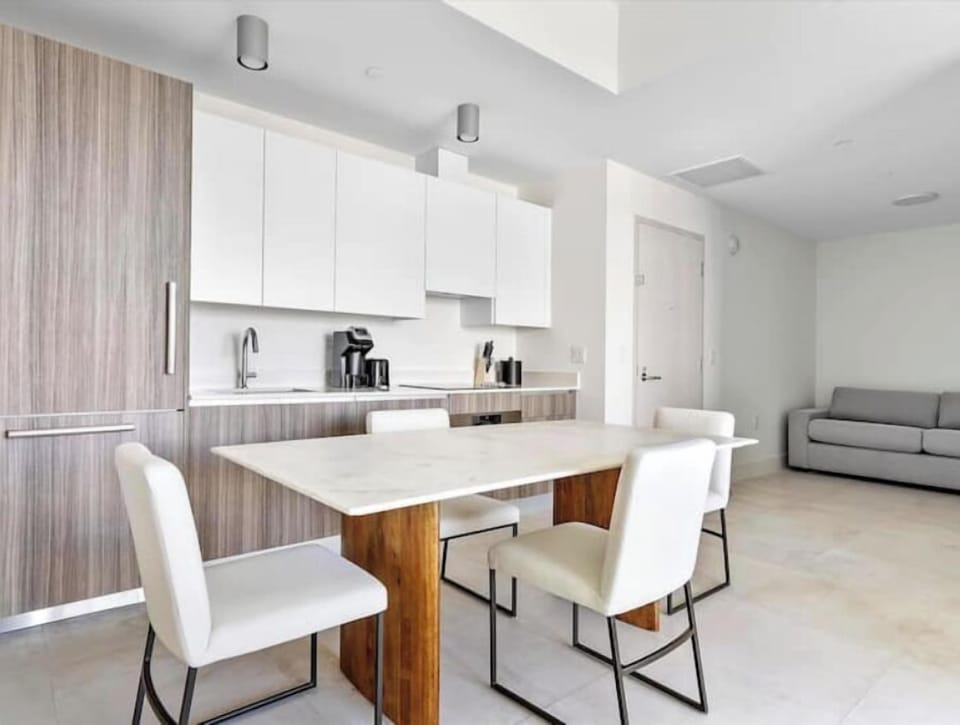 The kitchen features integrated appliances and light wood cabinetry.