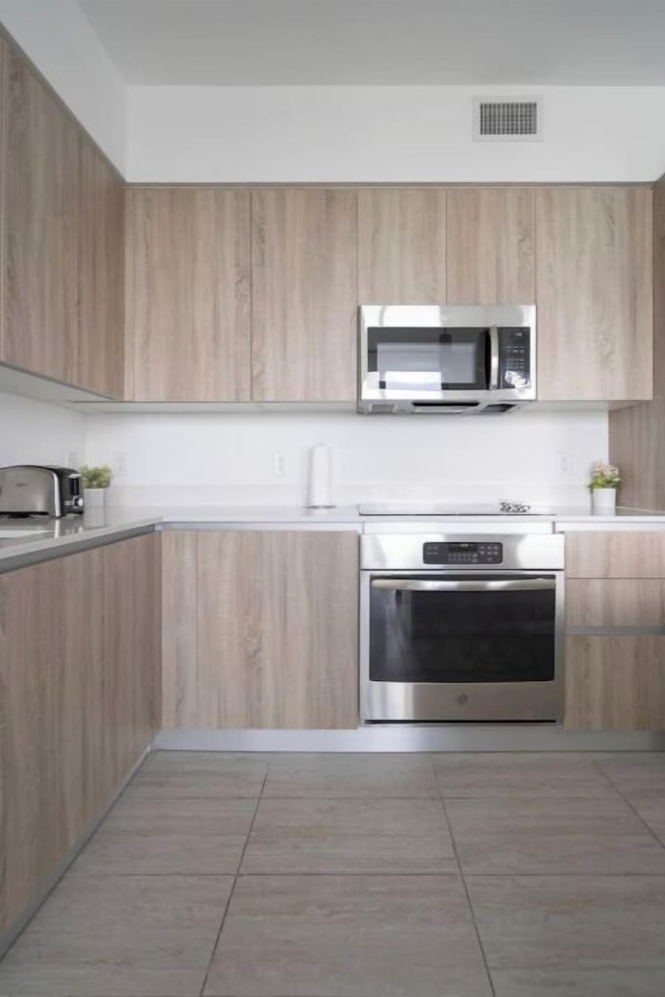 The kitchen features light wood cabinetry and modern appliances.