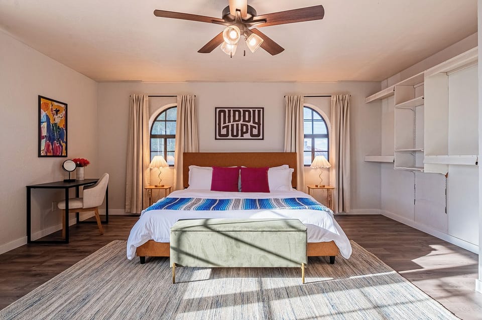 Master bedroom with king bed, ceiling fan, and plush beddings