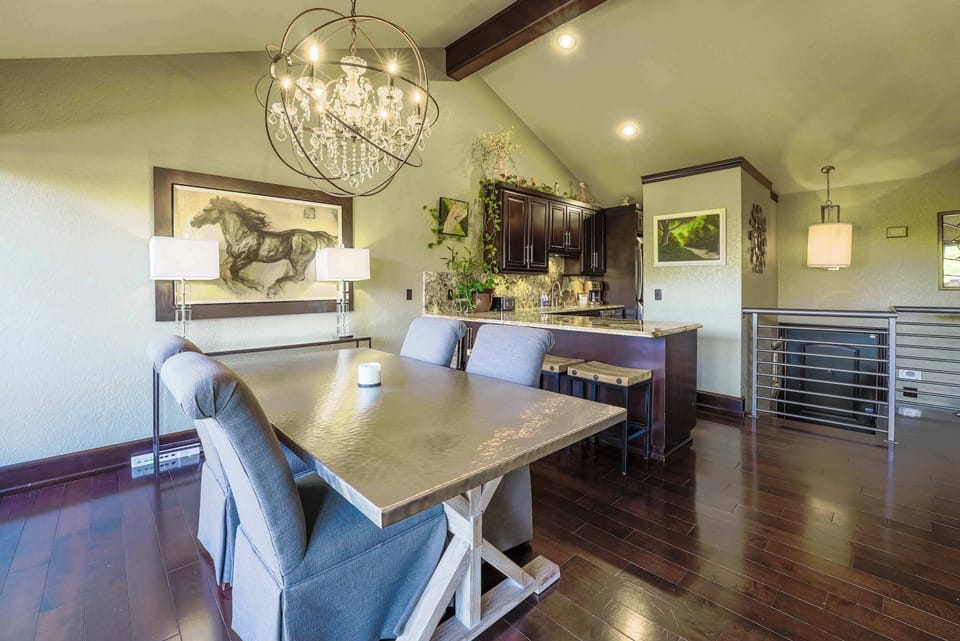 Dine at our elegant farmhouse table under a statement chandelier, with seating for six and open sightlines to the kitchen.