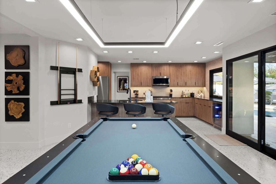 Enjoy the sleek pool table and open kitchen, perfect for entertaining and fun.