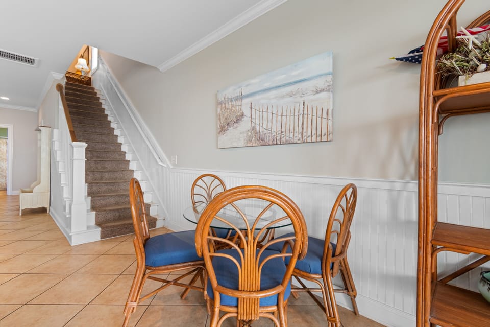 Gather around your charming coastal dining table, where beach-inspired artwork sets the scene for memorable meals together.