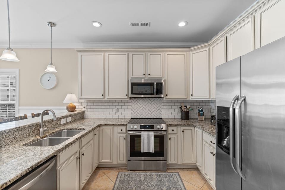 Your fully equipped kitchen awaits with granite counters, stainless appliances, and stylish subway tile backsplash for memorable meal prep.