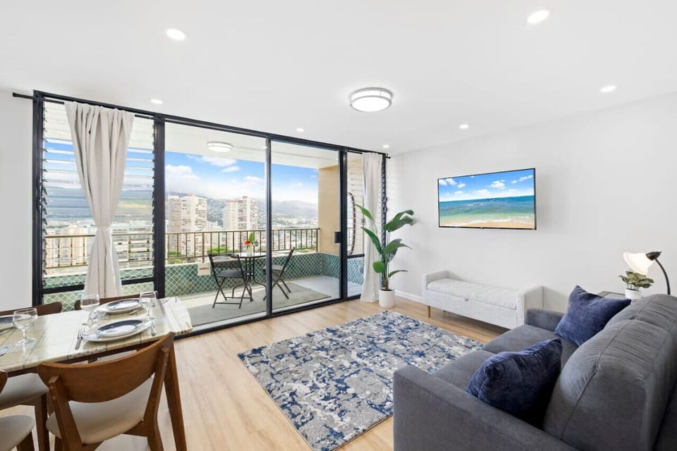 Living room with full size sofabed TV and dining room
