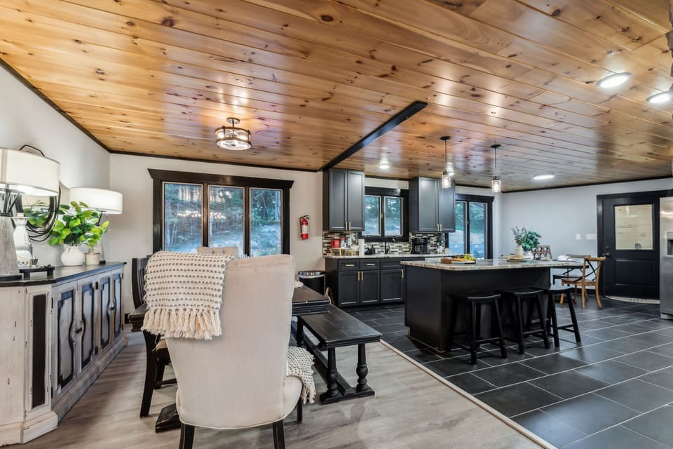 Open-concept dining and kitchen area with sleek cabinetry and large island.