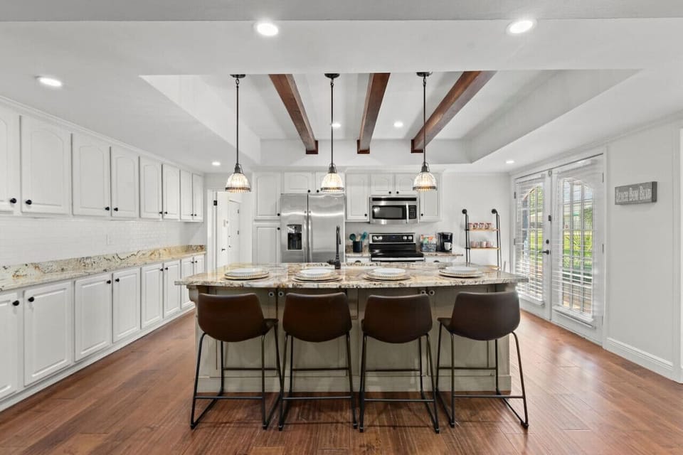 A bright, updated kitchen with sleek stainless steel appliances, a breakfast bar island, and fully stocked with everything you need for a convenient and enjoyable stay!