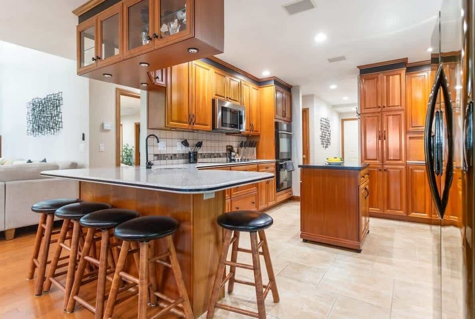 A spacious kitchen fit for cooking with a large central island and natural wood cabinets
