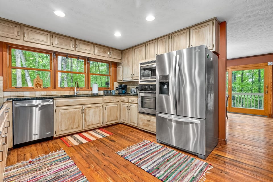 Enjoy cooking in this modern, open-concept kitchen, fully stocked with all the essentials for preparing any meal. The large windows offer views of the surrounding nature, while the open layout ensures you're never far from the ongoing conversations a