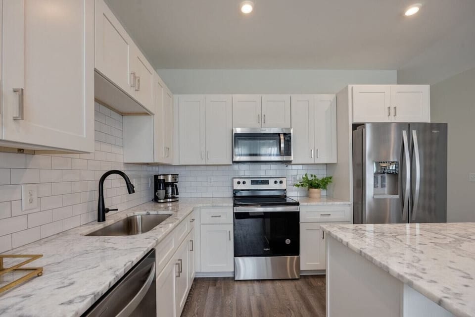 Full kitchen with stainless steel appliances and breakfast bar with seating for 2