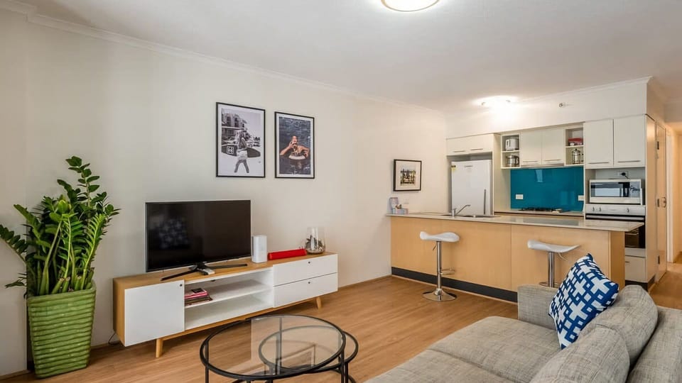 Modern urban living at its finest—enjoy a seamless flow between the gourmet kitchen and the comfortable living space, accented with lush greenery and contemporary art.