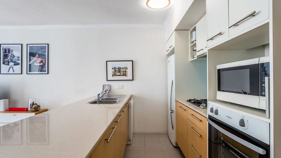 Prepare your favorite meals in this bright, well-equipped kitchen featuring a professional gas cooktop, modern oven, and high-spec microwave.