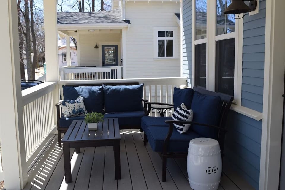 Deck lounge chairs on porch with pool across the street