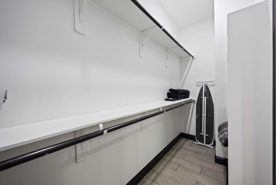 Walk-in closet, full-sized ironing board and iron.