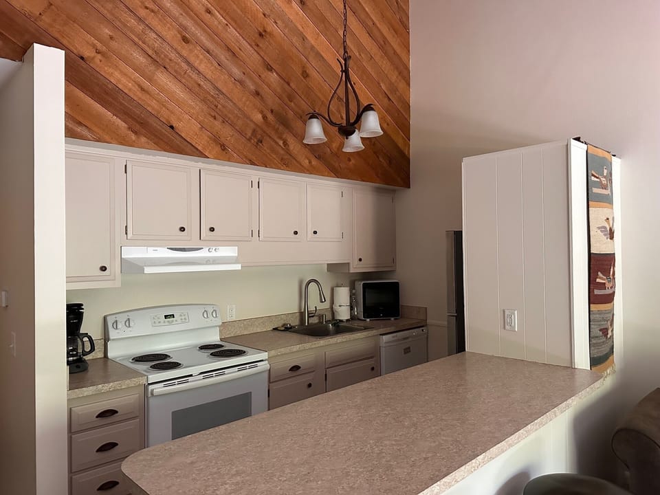 A nice kitchen with new coffee maker and new kettle and all you need to fuel up.