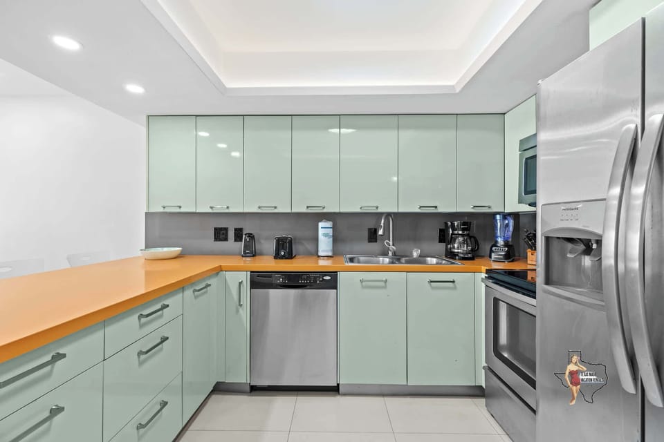 A spacious kitchen with sparkly stainless steel appliances and everything you’d need to prepare meals at home