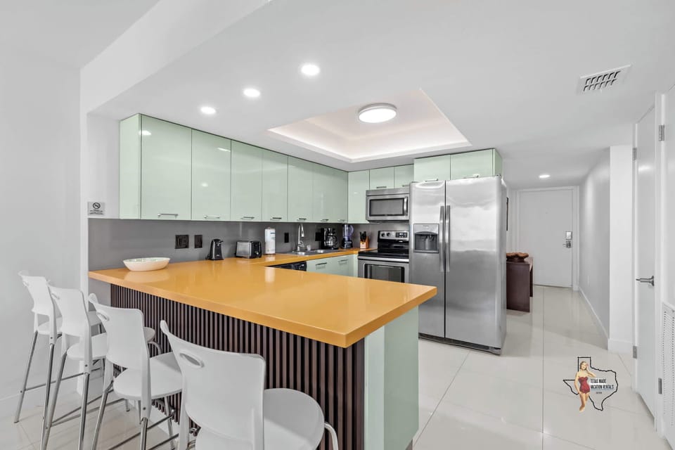 A convenient breakfast bar with four cushioned bar stools for a quick snack, coffee, or to work on your laptop if needed
