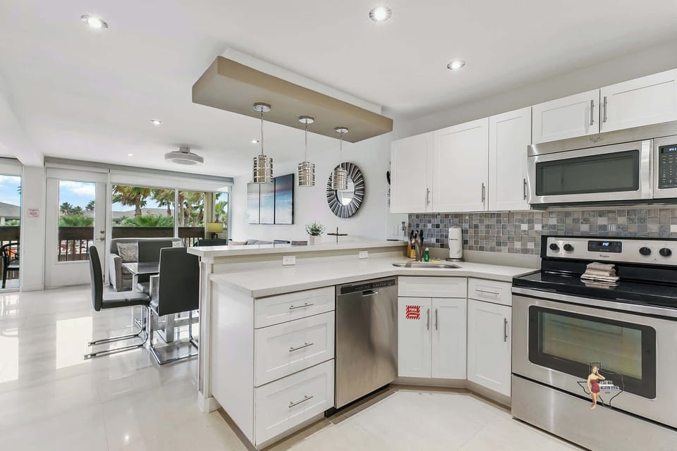 A spacious kitchen with shiny stainless steel appliances and everything you’d need to prepare meals