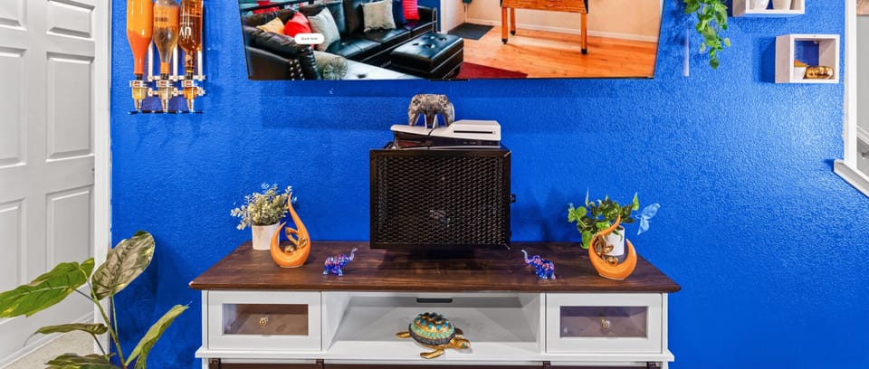 Unwind in a colorful, art-filled living room featuring a PS5 for gaming and streaming