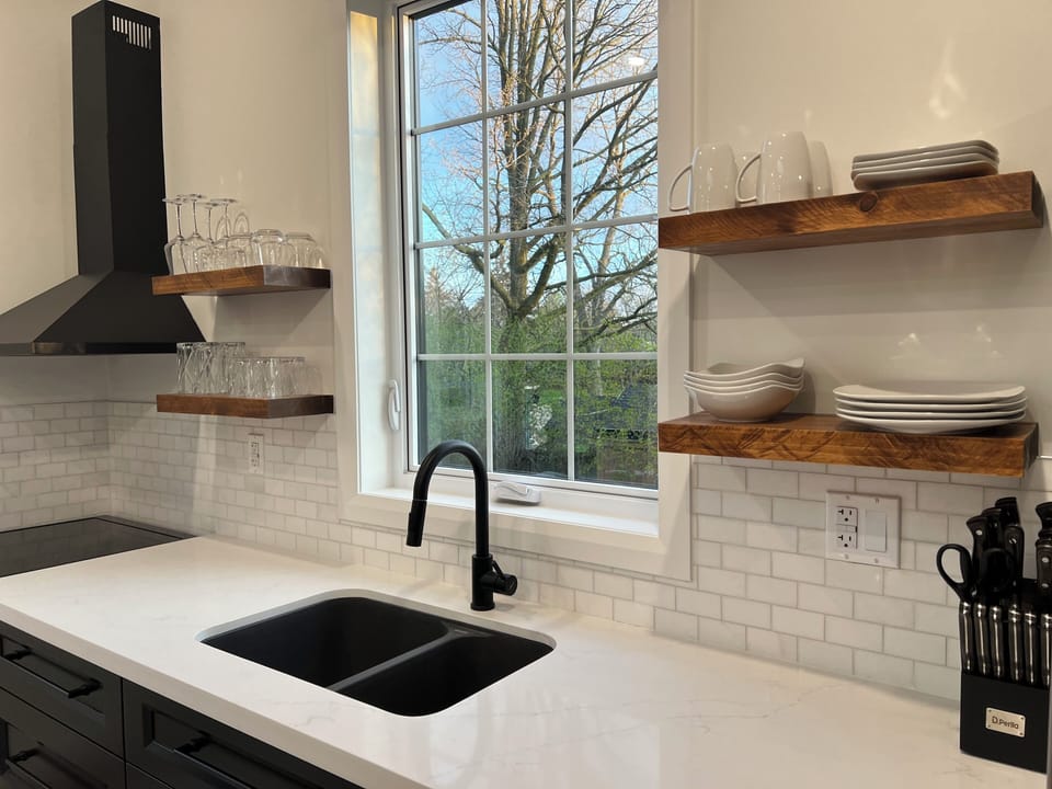 Modern kitchen with real wood floating shelves and quartz countertop.
