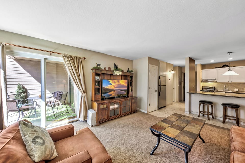 Relax in your spacious living area with comfortable leather seating, entertainment center, and private patio access for outdoor dining.