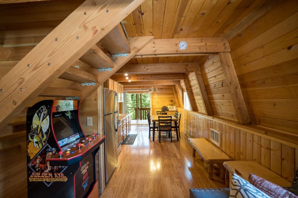 A cozy cabin with everything you need—kitchen, dining, and even an arcade game!