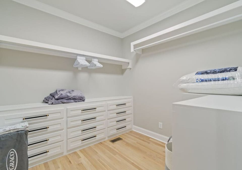 Large walk in master closet with hangars, extra pillows, and a pack n play