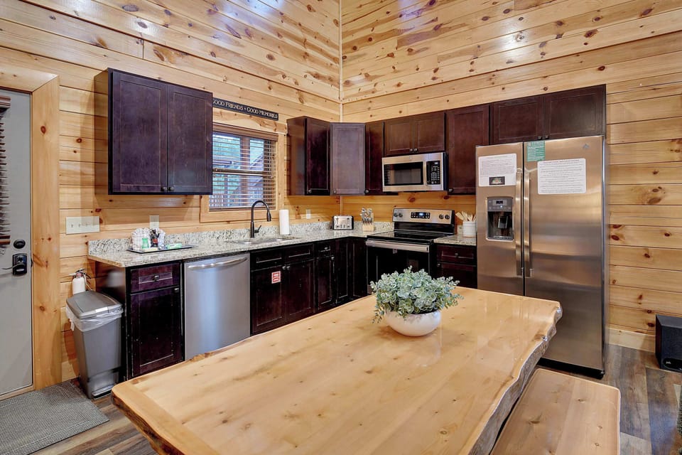 rustic kitchen with dark cabinetry and stainless steel appliances